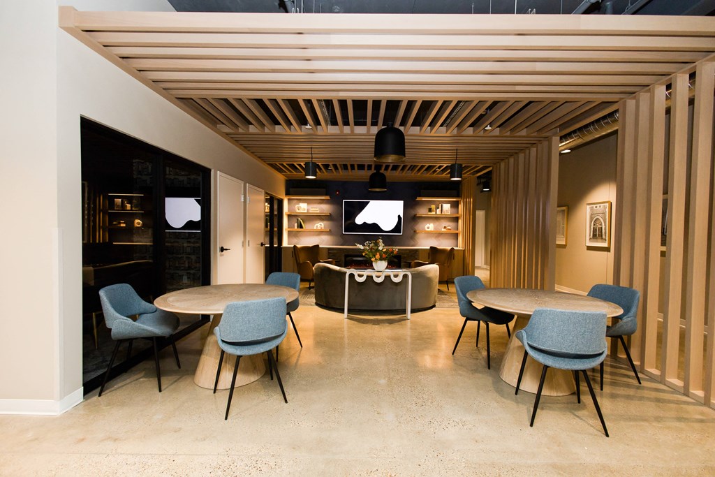 a dining room with tables and chairs and a living room with a television