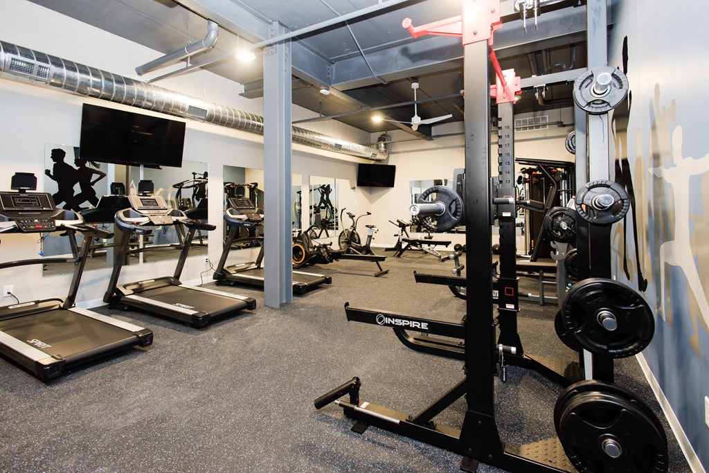 a gym with weights and other exercise equipment in a building with white walls