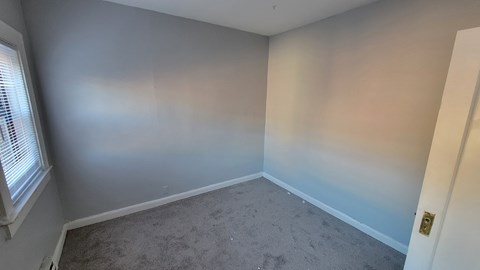 an empty room with blue and white walls and a window