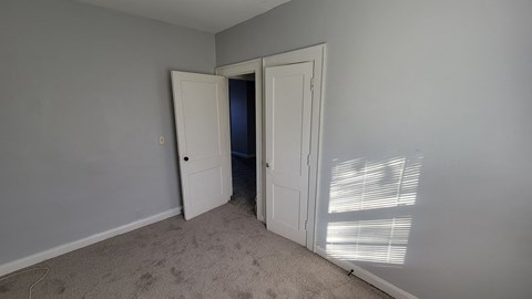 a bedroom with a door to a closet and an open doorway