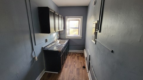 a small kitchen with black cabinets and a window