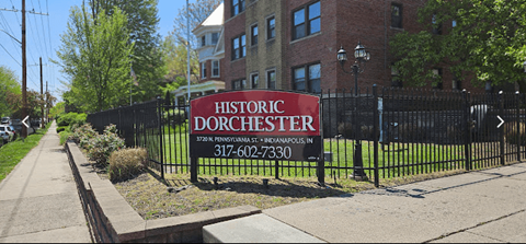 a sign in front of a wrought iron fence