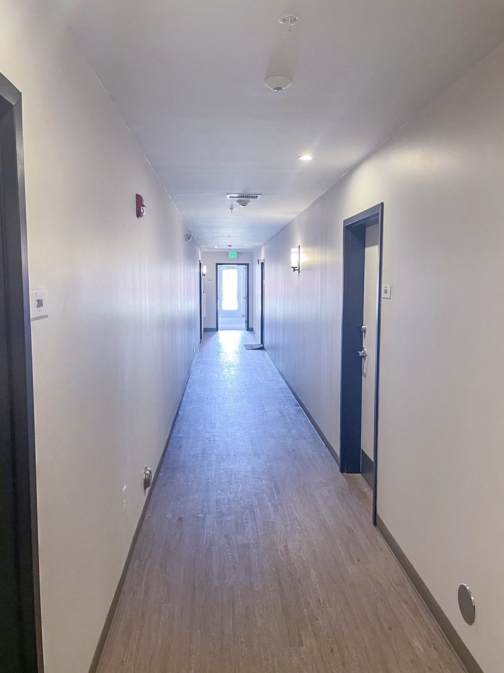 A long corridor with new wooden floors at The Hawks at River Art apartments