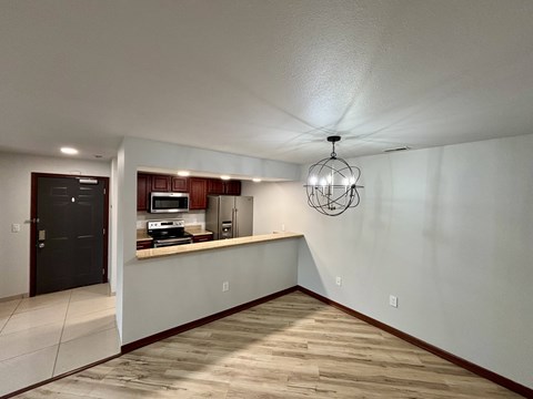A kitchen with a countertop and cabinets is visible from the living room.