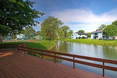a deck overlooking a lake with houses in the background