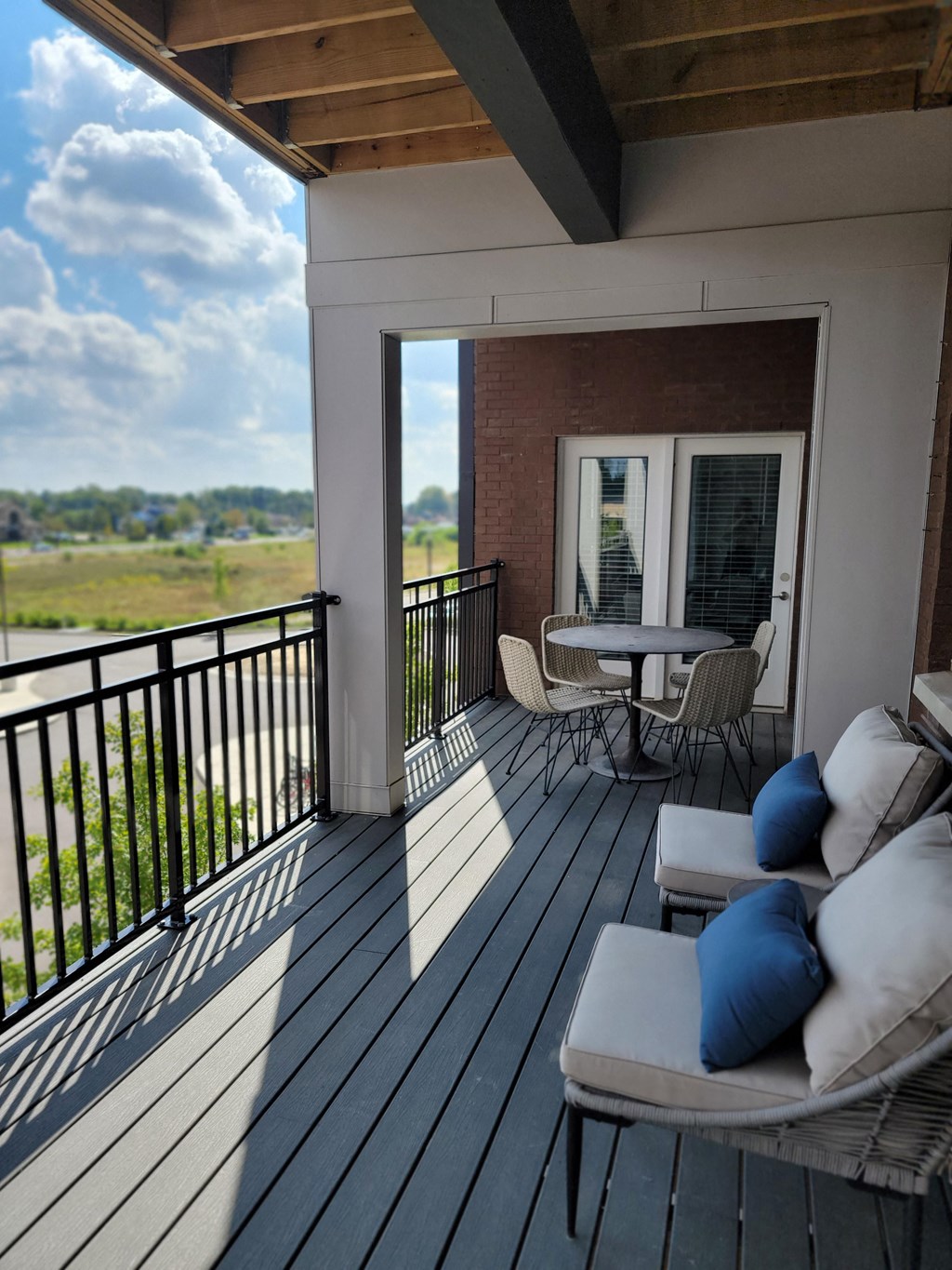 a porch with a view of the water and a couch and tables