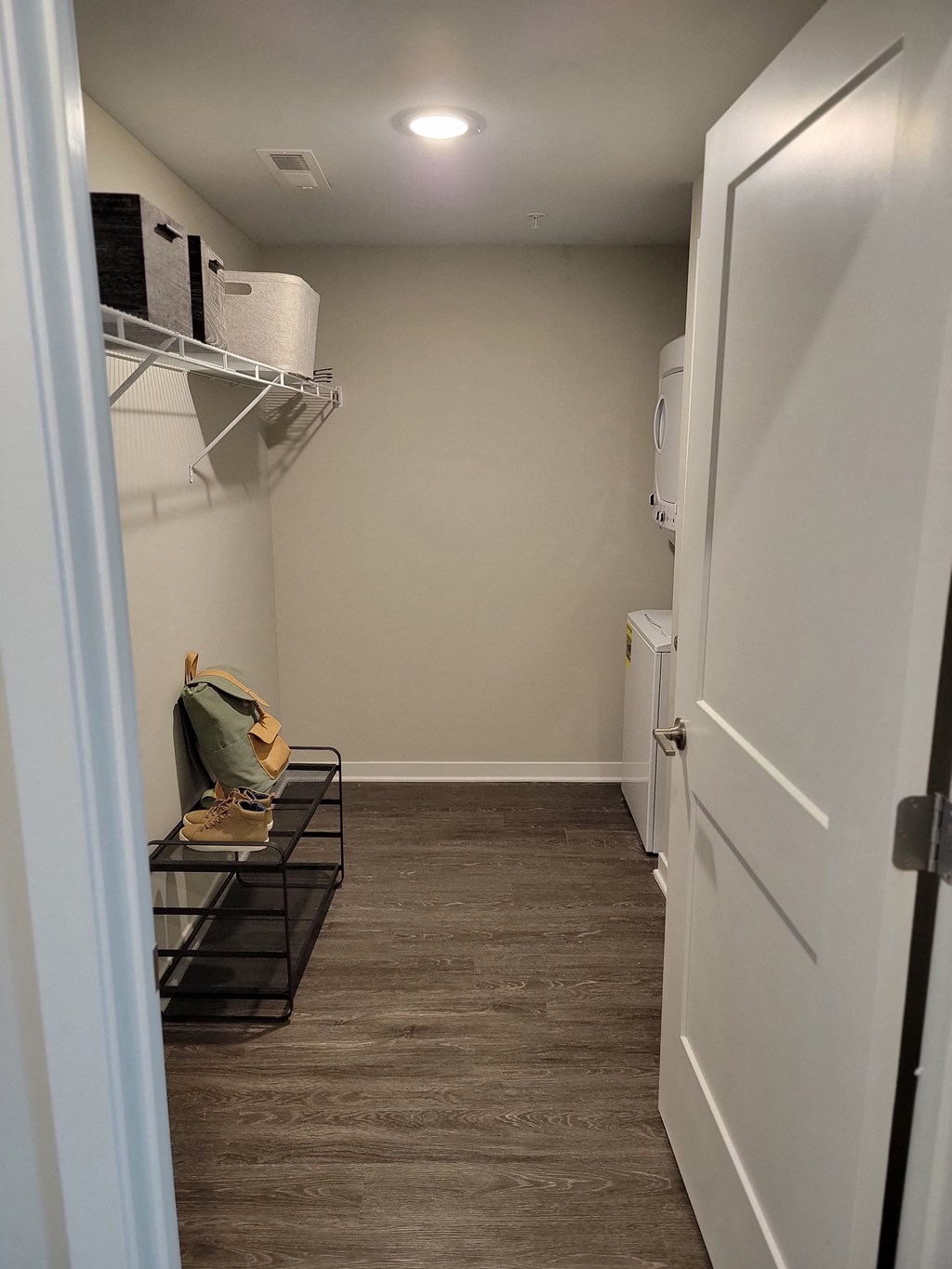 a room with a closet and a refrigerator and a white door