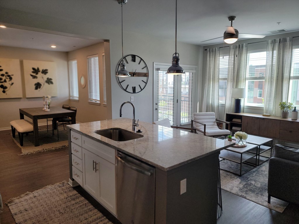 an open kitchen and living room with a large clock on the wall