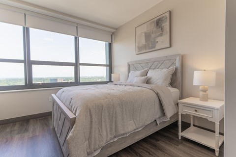 A bedroom with a large bed and a window overlooking the water.