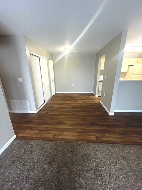 A long hallway with wood floors and white walls.