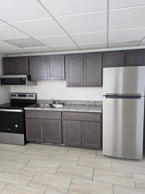 A kitchen with a white fridge and black oven.