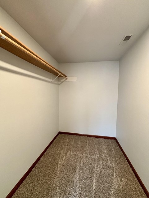 A room with a carpet and a white wall.