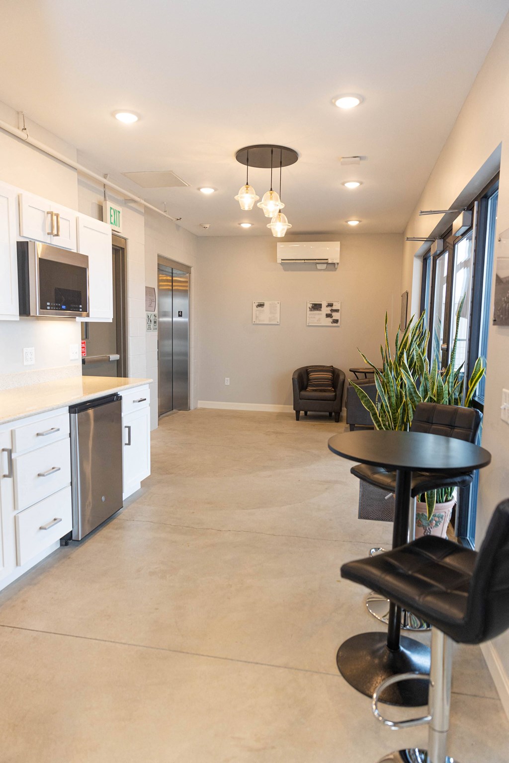 a kitchen and living room with a black table and chairs