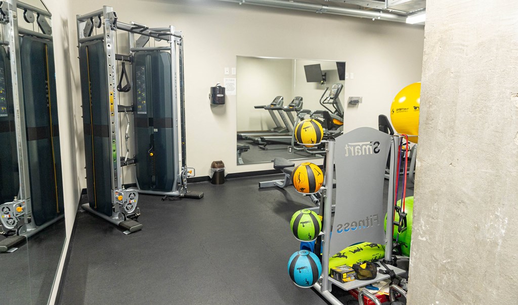 a workout room with weights and mirrors in a gym