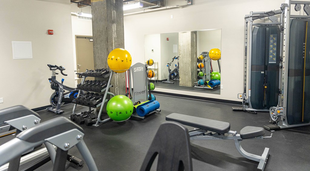 a gym with exercise equipment and mirrors in a building