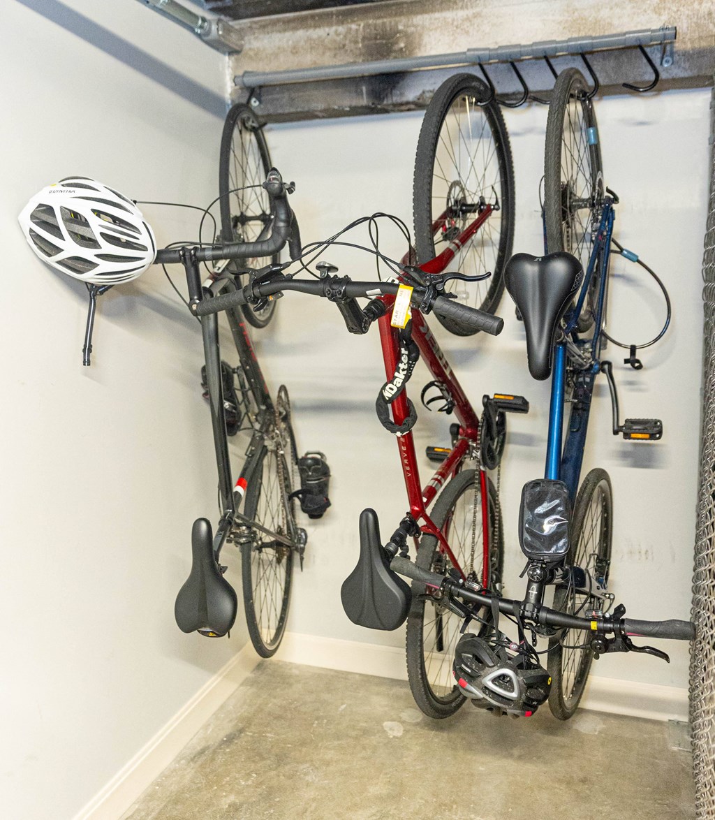 a bike rack in a garage with two bikes and helmets on it