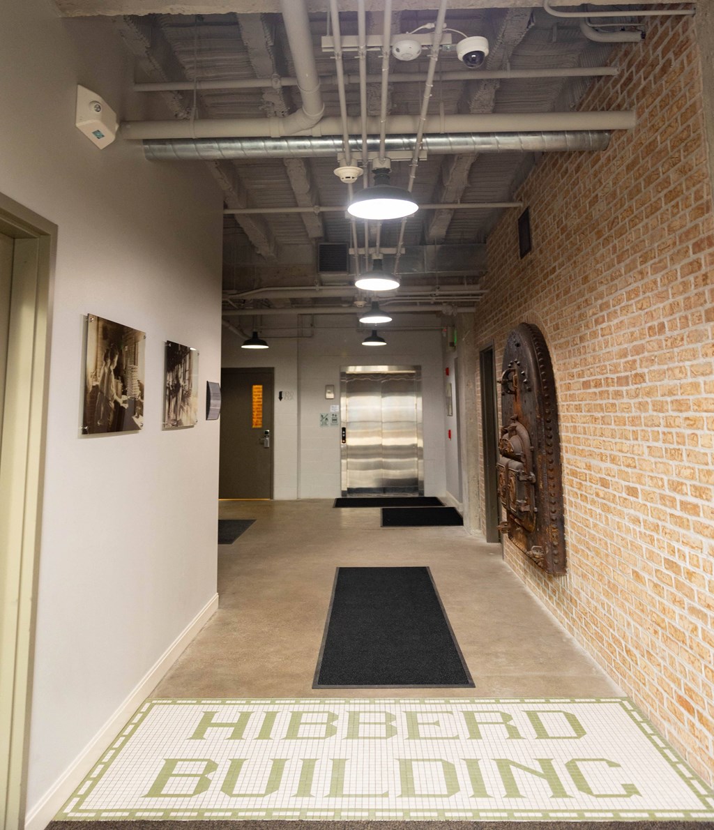 a hallway with brick walls and a rug in the center of the floor