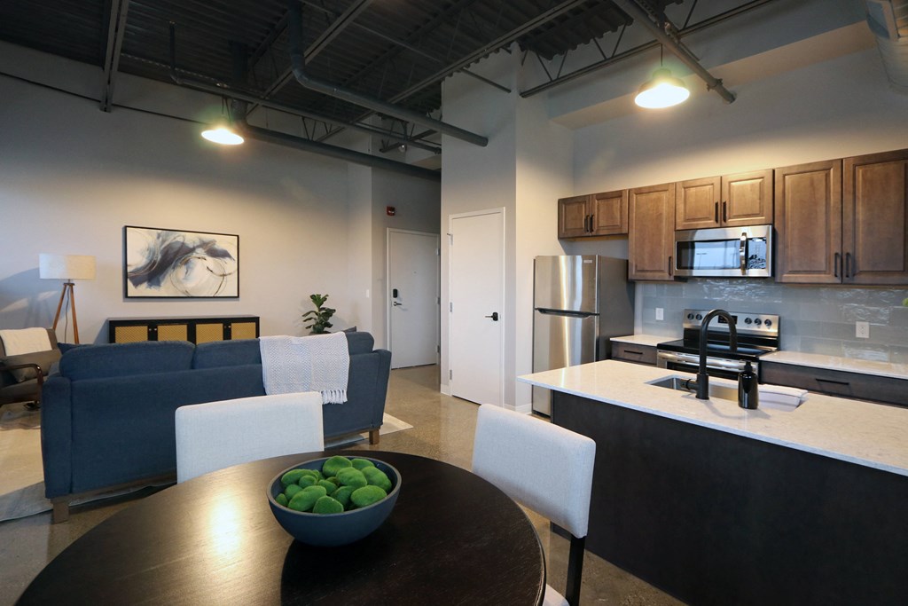a kitchen and living room with a wooden table and a bowl of limes