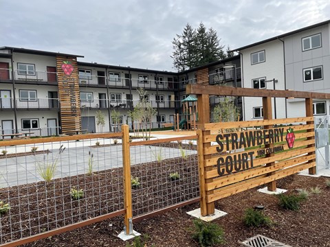 A wooden fence with a sign that says Strawberry Court.