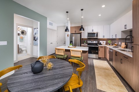 A modern kitchen with a dining table and chairs.