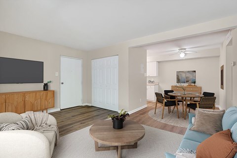 A living room with a white couch and a wooden coffee table.