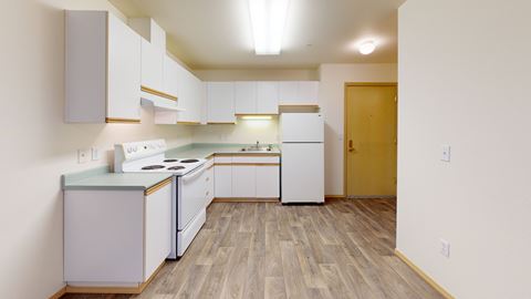 an empty kitchen with white appliances and white cabinets