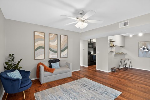 A living room with a blue chair and a grey couch.