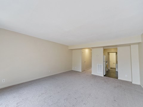 an empty living room with white walls and carpet