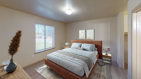 A bedroom with a large bed and a vase on a table.