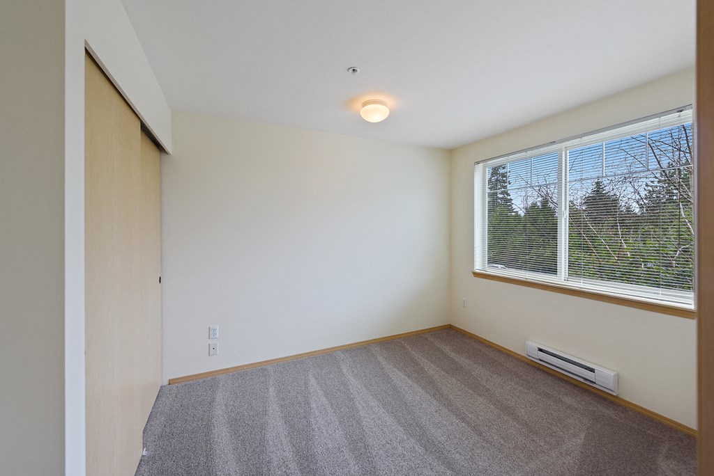 Bedroom with window at Alderwood Court in Lynnwood WA