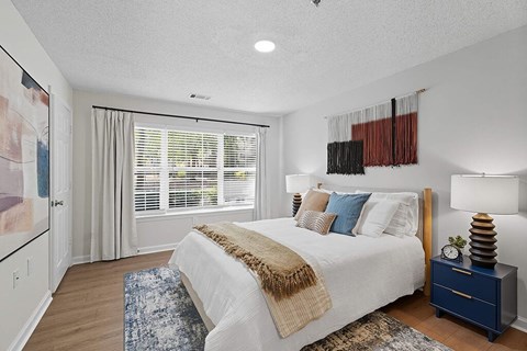 A bedroom with a large bed and a blue rug.