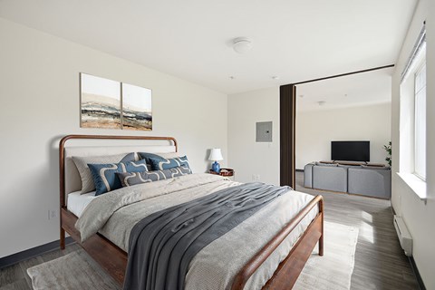 A bedroom with a large bed and a painting on the wall.
