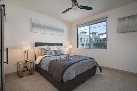 A bedroom with a large window and a ceiling fan at Scottsdale in Scottsdale AZ
