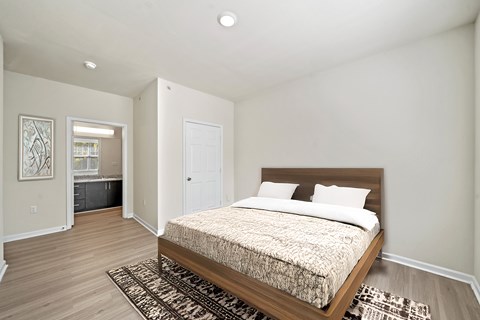 A bedroom with a large bed and a rug in front of it.
