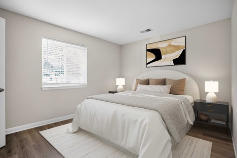A bedroom with a large bed and a painting on the wall.