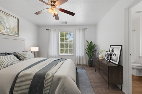 A bedroom with a large bed and a ceiling fan.