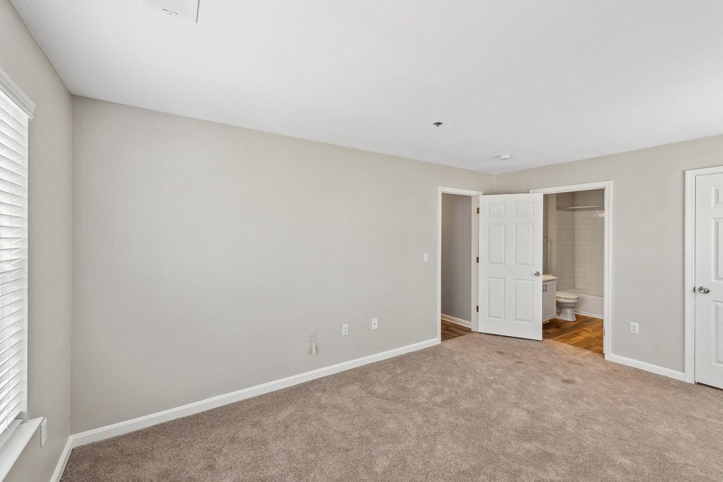 Carpeted bedroom with en suite at England Run Apartments in Fredericksburg VA