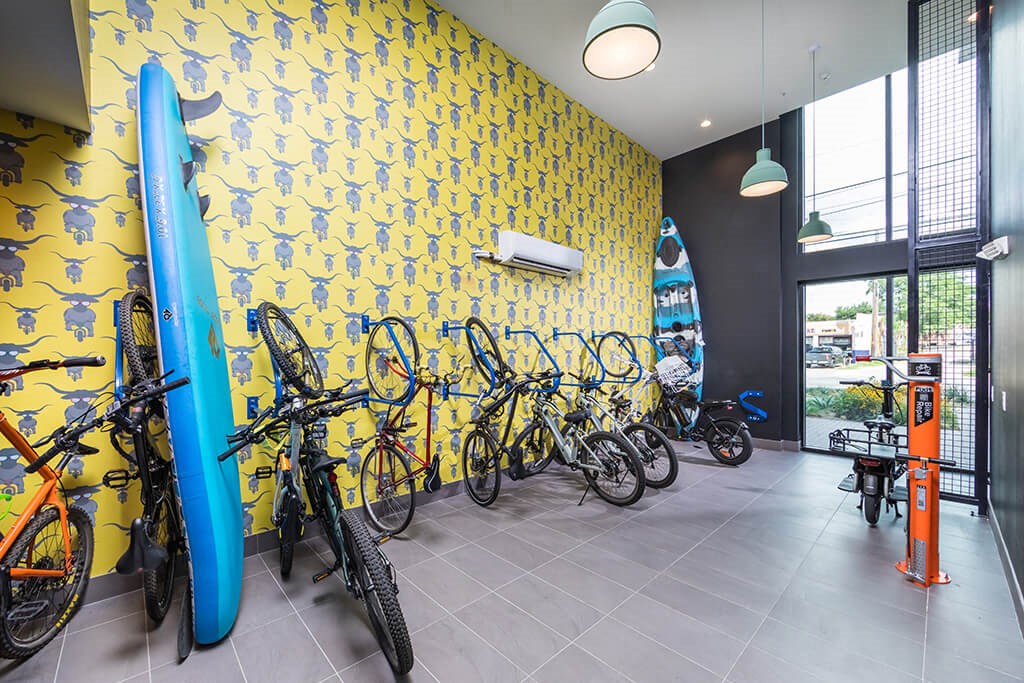 a room with bikes and a wall with surfboards