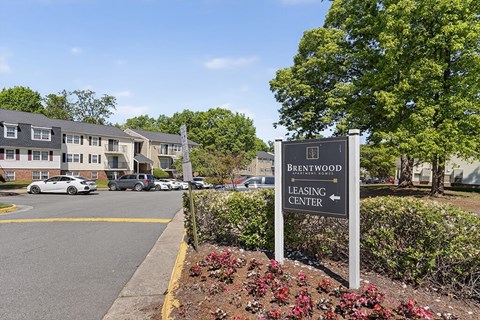 A sign for Brentwood Leasing Center stands in front of a building.