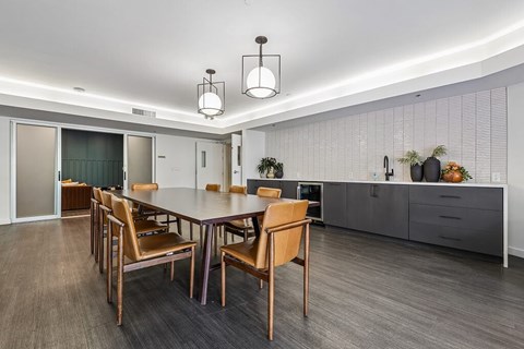 A dining room with a table and chairs.