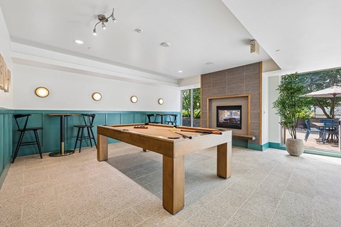 A room with a pool table and a fireplace.