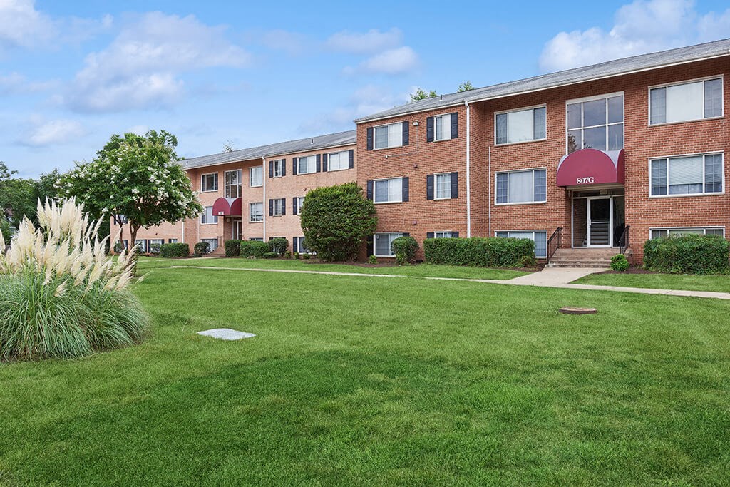 Building exterior with lawn at Leesburg Apartments in Leesburg VA