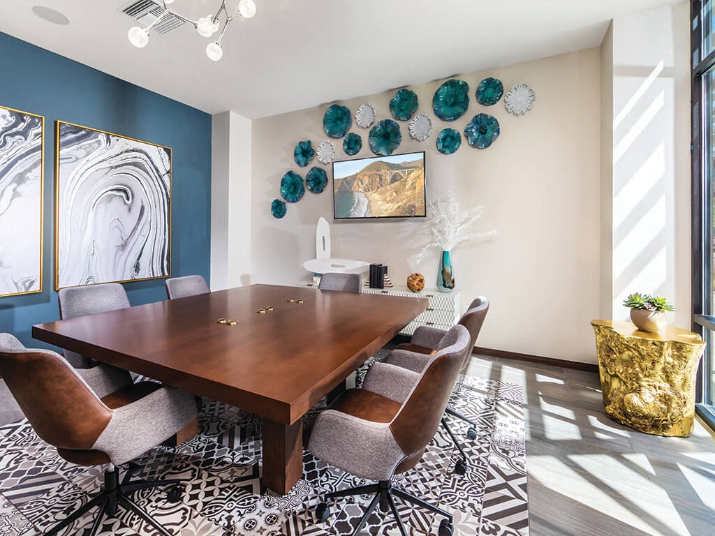 a dining room with blue and white walls and a wooden table and chairs