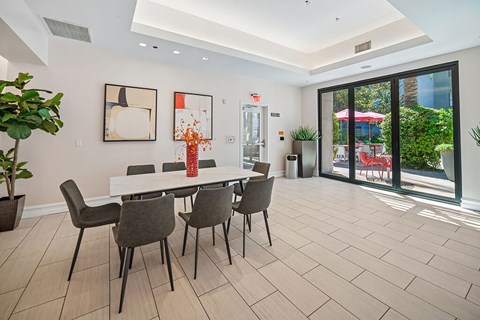 A dining room with a white table and chairs.