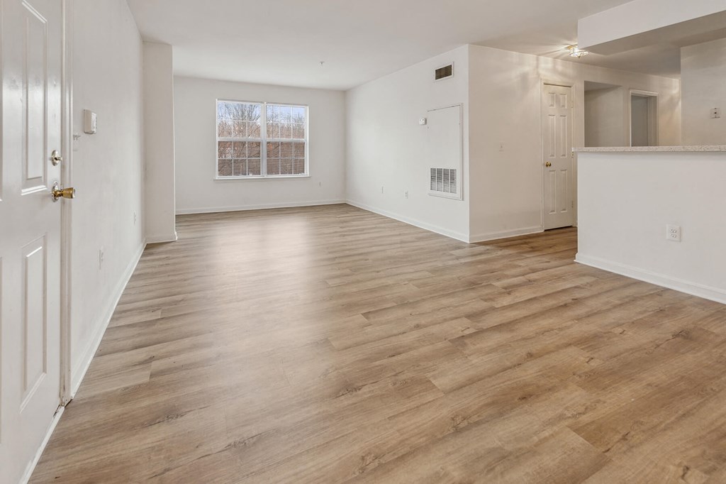 Living room with window and hardwood flooring at England Run Apartments in Fredericksburg VA