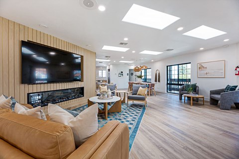 A living room with a large television and comfortable seating.