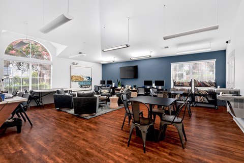 A room with a wooden floor and a large table with chairs.