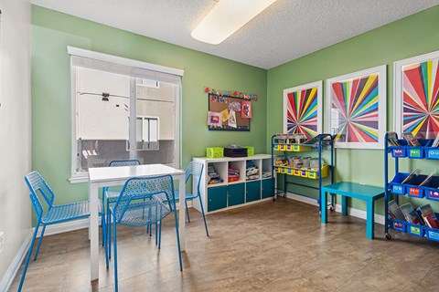 A room with a table and chairs and a window.
