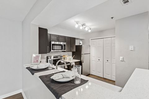 Fredericksburg Apartments for Rent - England Run North - Kitchen with Dark Cabinets, White Countertops, Breakfast Bar, and Appliances.