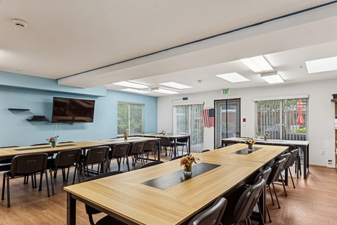 A conference room with a long table and chairs.